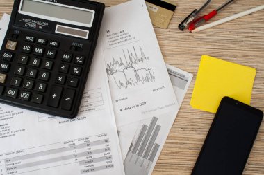 Hesap makinesinin kalemleri, kalemleri, çıkartmaları, cep telefonu, kredi kartı ve belgeleriyle toplam görüntüsü