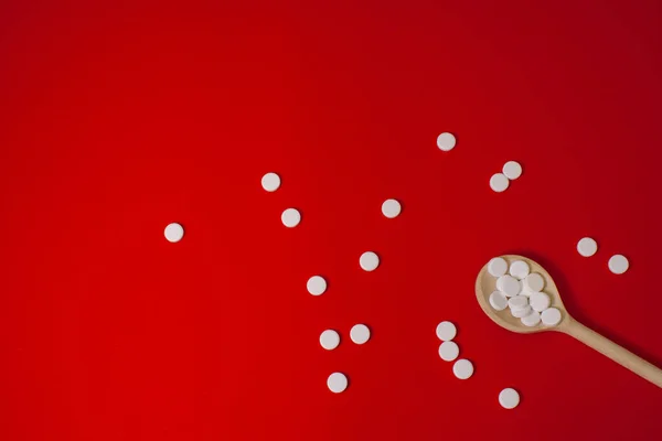 Pastillas Blancas Sobre Una Cuchara Madera Sobre Fondo Rojo —  Fotos de Stock