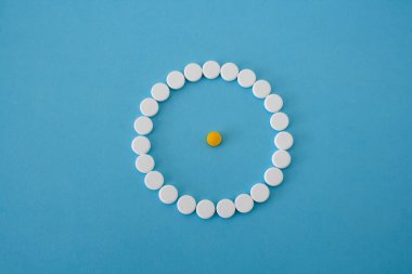 Mavi arka planda sarı haplı beyaz hap çemberi.