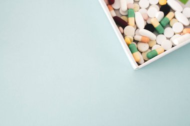 Renkli haplar ve kapsüller, çeşitli haplar, açık mavi arka planda, açık mavi arka planda, metin için boş alan