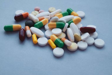 Mavi arka planda renkli haplar ve kapsüller, makro-sıcak haplar 