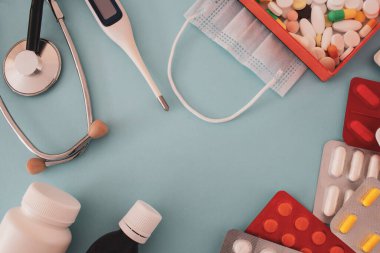 Renkli haplar ve kalp şeklinde kapsüller, soluk mavi arkaplandaki kavanozdan, görüntünün sol tarafında yer alan, metin, aşk ve izole edilmiş bir alan.