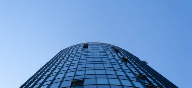 Pankart. Mavi gökyüzünün arka planında yüksek katlı bir iş binasının manzarası. Gökyüzü arka planındaki iş merkezi. Gökdelen, finans, yatırım, izole edilmiş