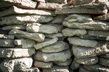 Güzel beton parçaları, yakın plan taş duvar. Kapalı çimento parçaları ve gün ışığında derin boşluklar. Taş dokusu ve arka plan. Parçalanmış taş, beton ve tuğla. Taş Taşlar