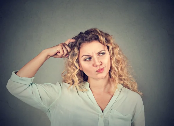 Woman scratching head thinking about something looking up — Stock fotografie