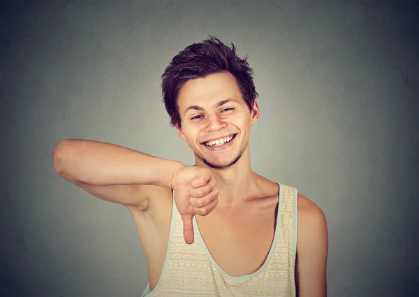 Sarkastischer glücklicher junger Mann zeigt Handbewegung mit dem Daumen nach unten — Stockfoto