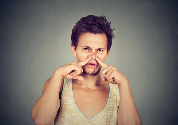 disgusted man pinches nose disgusted something stinks bad smell