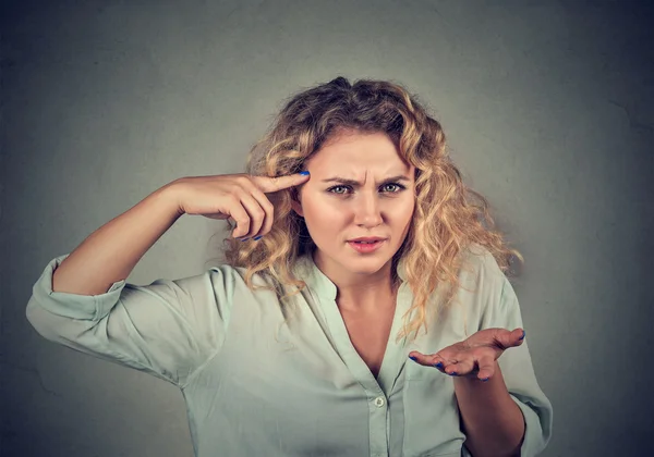 Angry woman gesturing against temple are you crazy? — Stock Photo, Image