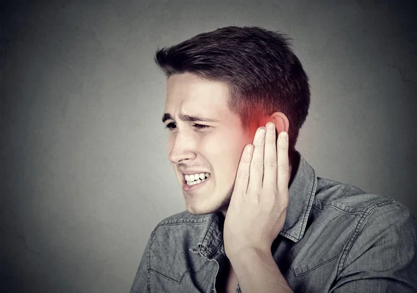 Tinnitus. Sick man having ear pain touching his painful head — Stock Photo, Image