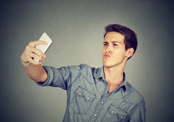 Hombre de aspecto divertido tomando fotos de sí mismo con el teléfono inteligente —  Fotos de Stock