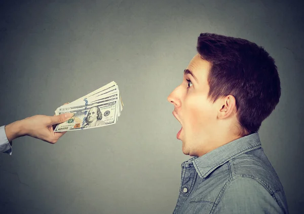 Shocked surprised man looking at offered cash dollar bills — Stock Photo, Image