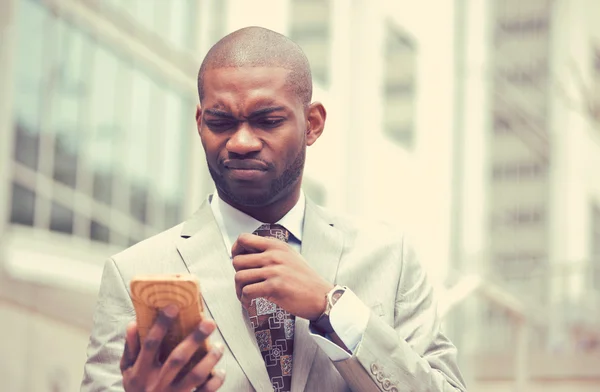 Olycklig ung man pratar SMS på mobiltelefon utomhus — Stockfoto