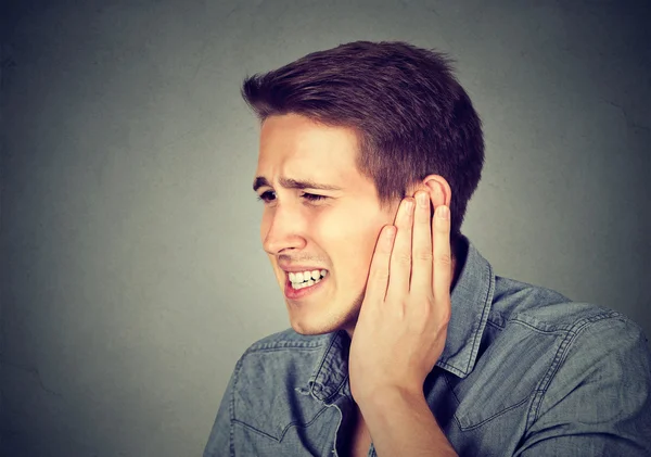 Tinnitus. Kranker Mann mit Ohrenschmerzen, die seinen schmerzenden Kopf berühren — Stockfoto