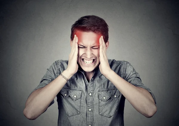 Hombre estresado con dolor de cabeza aislado sobre fondo de pared gris — Foto de Stock