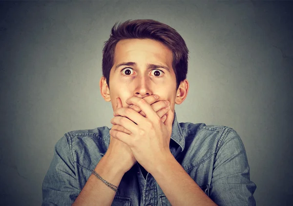 Shocked young man covering his mouth with hands — Stock Photo, Image