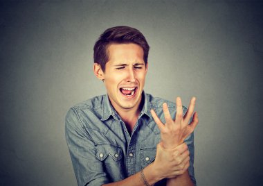 Young man holding his painful wrist. Sprain pain