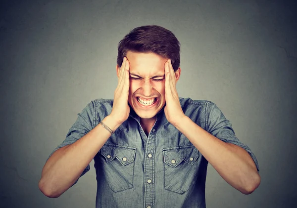 Stressad man med huvudvärk isolerade på grå vägg bakgrund — Stockfoto