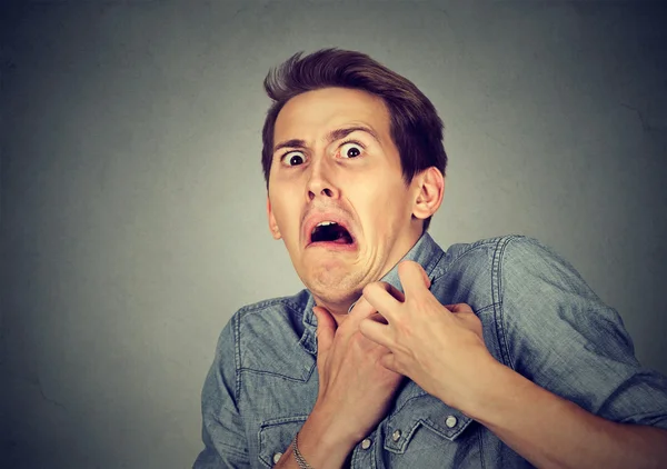 Hombre mirando sorprendido asustado tratando de protegerse de desagradable — Foto de Stock