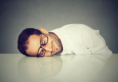 Man with glasses sleeping on a desk clipart