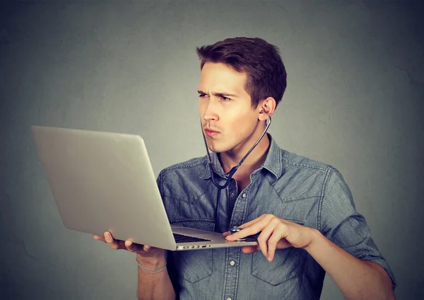 Homem ouvindo computador com estetoscópio olhando para laptop pc . — Fotografia de Stock