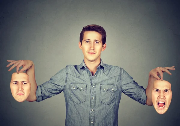 Hombre sosteniendo dos máscaras de emoción diferentes — Foto de Stock