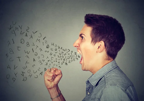 Homme en colère criant avec alphabet lettres volant hors de la bouche grande ouverte — Photo