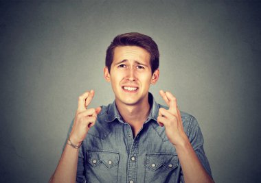 Genç adam onun parmak çarpı işareti tutarak bir dilek yapma 