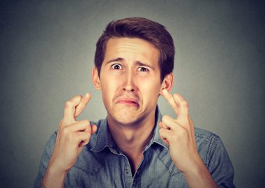 Genç adam onun parmak çarpı işareti tutarak bir dilek yapma 