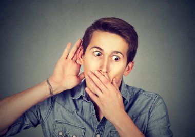 meraklı genç adam bir konuşmaya dinliyor 