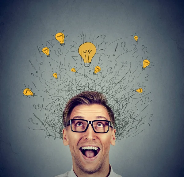 Happy man in glasses looking up with light idea bulb above head — Stock Photo, Image