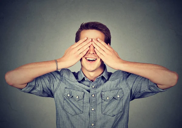 Překvapený muž si zakryl oči s úsměvem — Stock fotografie