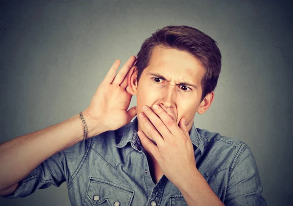 Neugieriger junger Mann hört einem Gespräch zu — Stockfoto