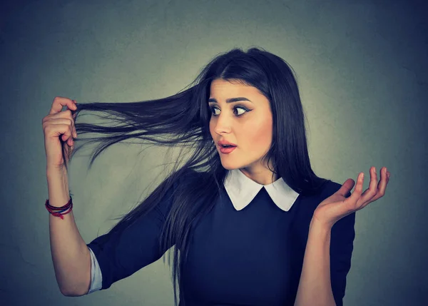 Расстроенная женщина удивлена, что она теряет волосы, отступая волос — стоковое фото