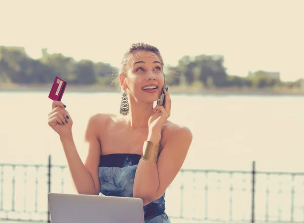 Vrouw praten op mobiele telefoon bedrijf credit card en laptop — Stockfoto