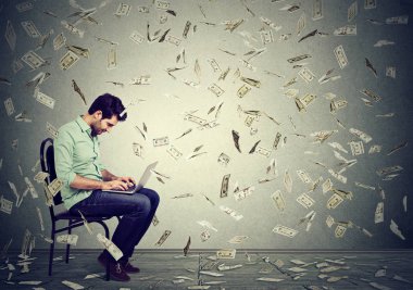 Para kazanmak online iş kurma dizüstü kullanan genç adam 