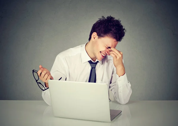 Cansado homem de negócios esfregando o olho sentado à mesa com laptop — Fotografia de Stock
