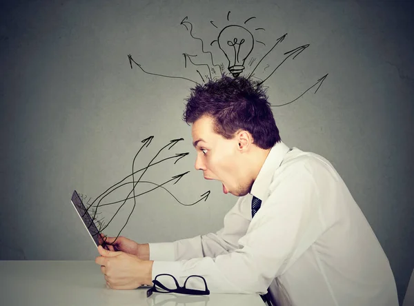 Shocked young man working on laptop — Stock Photo, Image