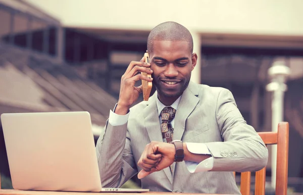 Affärsman som arbetar på laptop prata telefon tittar på armbandsur — Stockfoto
