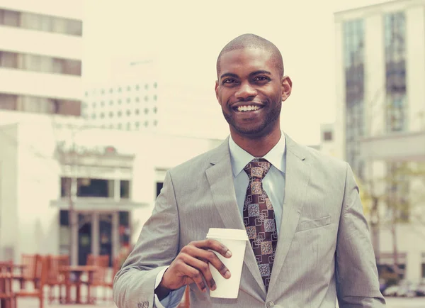 Young man with coffee cup smiling — Stock Photo, Image