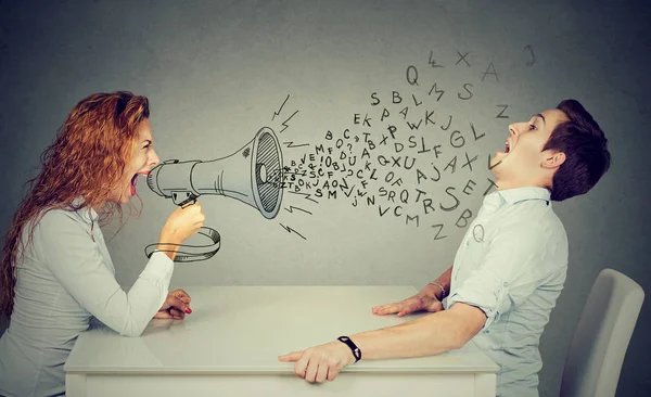 Angry woman shouting at man blown away by wave of alphabet letters — Stock Photo, Image