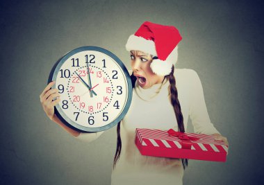 Noel Baba şapkası saat hediye kutusu tutan bir acele kadında vurguladı