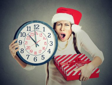 Noel Baba şapkası saat hediye kutusu tutan bir acele kadında vurguladı