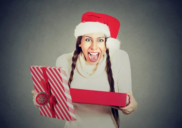 Aufgeregte Frau mit rotem Weihnachtsmann-Hut öffnet Geschenkbox — Stockfoto