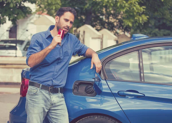 Handsome man with credit card opening fuel tank of new car — Stock Photo, Image