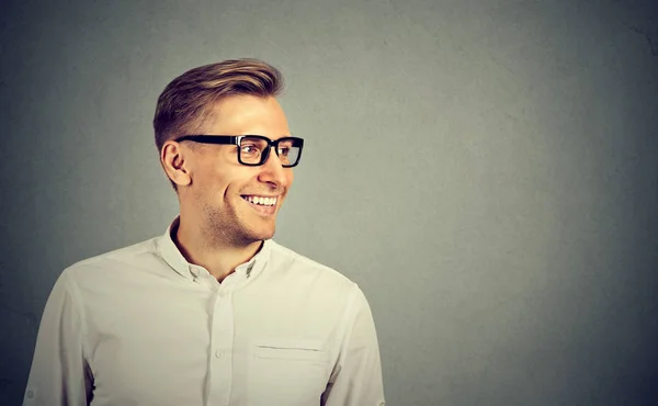 Fiatal férfi mosolyogva nézett a oldalra szemüveg — Stock Fotó