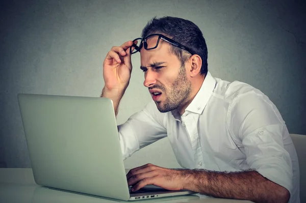 Mannen med glasögon har syn problem förvirrad med laptop programvara — Stockfoto