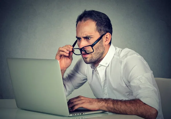 Человек в очках, имеющих проблемы со зрением путают с ноутбуком программное обеспечение — стоковое фото