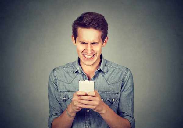 Angewiderter Mann liest eine SMS — Stockfoto