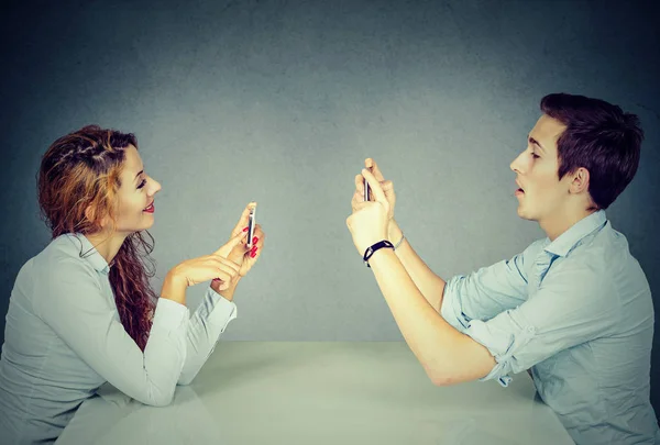 Man woman using mobile phones texting taking pictures — Stock Photo, Image