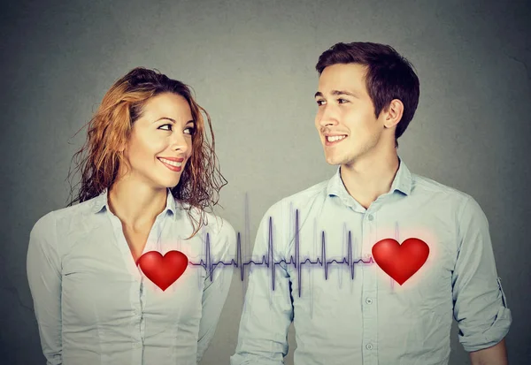 Mann Frau sieht einander mit roten Herzen durch Kardiogramm verbunden — Stockfoto